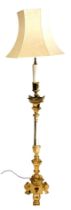 A brass standard lamp, of Gothic altar form, with a floral cream shade, 180.5cm high.