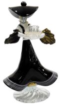 A Murano glass candlestick, of a figure of a lady wearing a black and white striped frilled dress, o