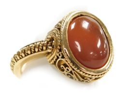 A Continental gentleman's cornelian cabochon signet ring, in yellow metal with filigree decoration,