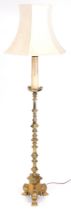 A brass standard lamp, of Gothic altar form, with a floral cream shade, 174cm high.