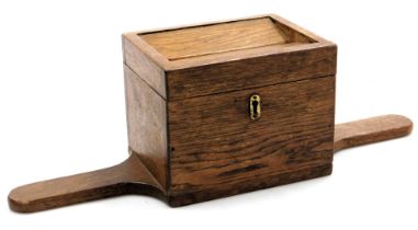 An early 20thC oak offertory box, with a hinged lid, 45cm wide.