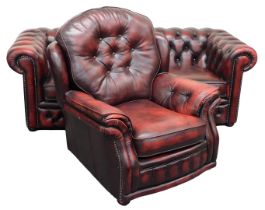 An ox blood leather Chesterfield sofa, with button back and arms, loose cushion seats, raised on bun