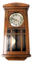 An early 20thC mahogany cased wall clock, the silvered dial bearing Arabic numerals, eight day movem