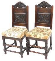 A pair of Victorian oak hall chairs, the foliate carved crest rail additionally carved with two armo