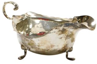 An Edward VII silver sauce boat, with a scroll handle, raised on three paw feet, Chester 1907, 4.7oz