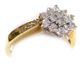 An 18ct gold and diamond flower head ring, set with fourteen diamonds, in a basket setting, approx 0