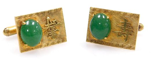 A pair of Chinese cabochon jade set cuff links, on a rectangular face bearing a raised single charac