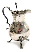 A Victorian silver cream jug, of pear shaped form, with a double scroll handle, raised on three shel
