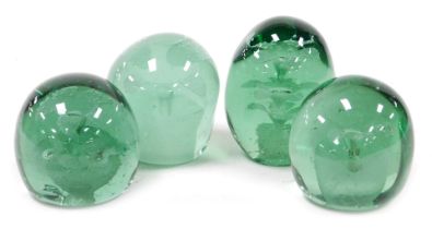 Four 19thC green glass dump paperweights, each decorated internally with flowers and a vase, one wit