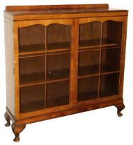 An early 20thC mahogany display cabinet, with two astragal glazed doors enclosing two wooden shelves