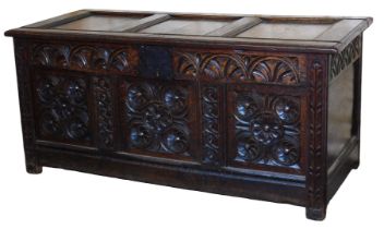 A 17thC carved oak chest, with a triple panel top, bearing initials to the front KN, opening to reve