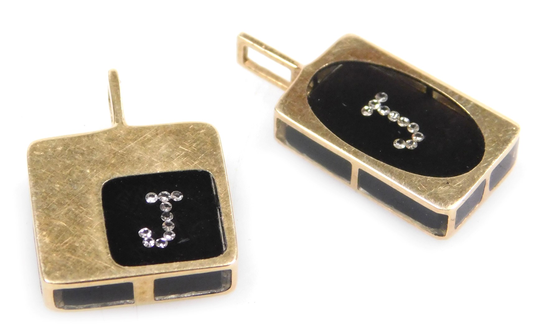 Two French black onyx diamond set initial pendants, initial J, set in yellow metal.