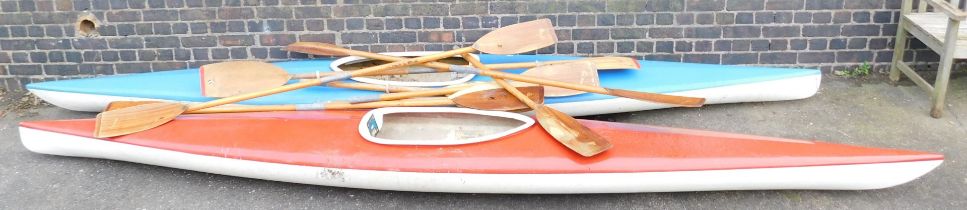 Two fibreglass canoes and various pairs of oars.