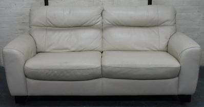 A two seater cream upholstered leather sofa.
