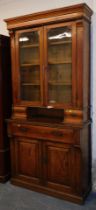 A Victorian cupboard bookcase, with two glazed doors over two trinket drawers, above six single long