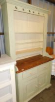 A painted pine dresser, open plate rack over two drawers above two doors, raised on plinth base.