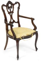 A Victorian open armchair, with carved splat, raised on slender cabriole supports.