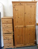 A pine wardrobe of two doors, and a pair of three drawer bedside chests.