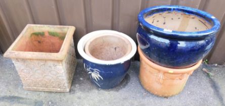 A blue ceramic terracotta planter, two further circular planters and one square terracotta planter.