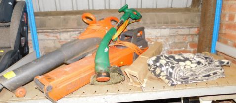 A Flymo garden vac, another large Flymo garden vac, a strimmer, and a large blanket.