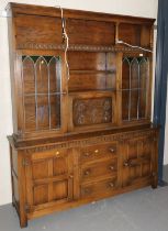 An oak dresser, open gallery to top, above two shelves over fall front, flanked by two glazed doors,