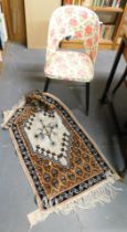 A machine made rug and a floral upholstered chair.