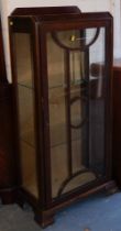 A mahogany veneered display cabinet, with single glazed panel door and two doors to side, raised on