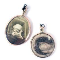Two locket pendants, comprising a 9ct gold memorial locket pendant, set with two babies curls, 2.5cm