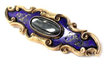 A Victorian memorial brooch, of elongated form set with blue enamel and raised scroll work, with a c