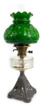 A 19thC oil lamp, with green moulded glass shade, clear glass central reservoir, on a cast pierced m