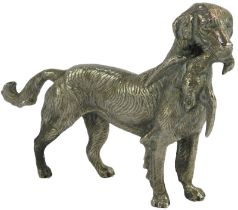 A cast white metal model of a Labrador retriever, holding duck in mouth, 16cm high.