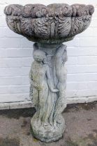 A composition bird bath, the circular top carved with leaves, the column carved with three nude fema