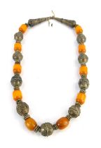 An Eastern inspired white metal and butterscotch amber necklace, the oblong beads of butterscotch am