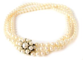 A three row cultured pearl choker, with a clustered clasp set with tiny diamonds and cultured pearls