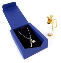 Two Swarovski Crystal items, comprising a golf and caddy brooch, and a heart shaped locket and key p