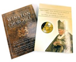 Two commemorative coin folders, for Winston Churchill and The Life of John Paul II, containing some