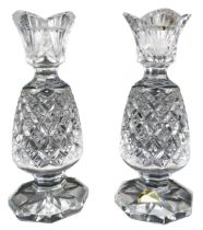 A pair of Waterford crystal candlesticks, modelled as pineapples, on octagonal bases, with paper lab