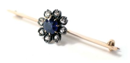 A bar brooch set with central cluster, with a central blue stone surrounded by tiny diamonds, in pla