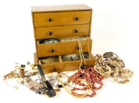 An oak four drawer jewellery box and contents, comprising Pulsar, Timex and Roamer ladies watches, a