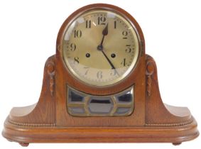 An early 20thC oak cased mantel clock, the circular silvered dial bearing Arabic numerals, eight day