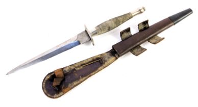 A Fairbairn-Sykes fighting knife, with cross hatched handle, in leather scabbard, length of blade 17