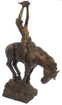 After Buck McCain. Native American resin figure with arms raised holding skull, on horseback, on roc