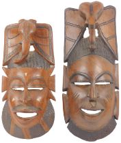 Two tribal hardwood masks, each surmounted by an elephant head, possibly Gambian, 52cm high and 44cm