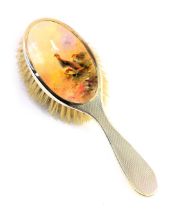 A George V silver mounted dressing table hairbrush, inset with a Royal Worcester porcelain plaque de