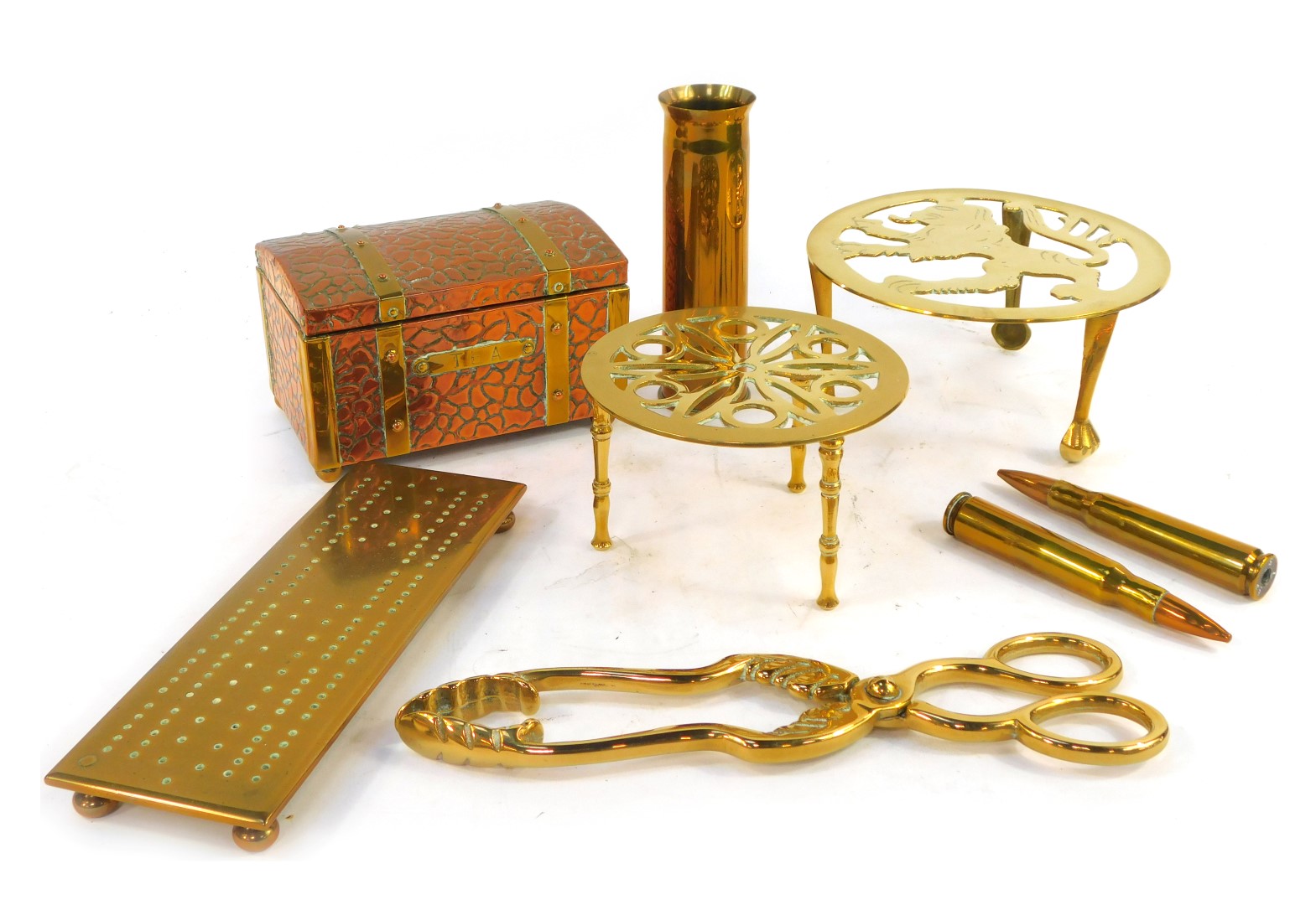 A group of brassware, to include trivet, cribbage board, tea canister modelled as a chest, shell cas