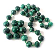 A malachite beaded necklace, each bead of rough cut spherical form, of graduated design, the largest