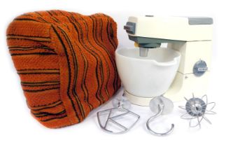 A Kenwood Chef mixer, with various attachments, and orange fabric cover.