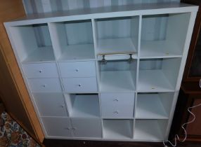 A wall unit, comprising various recesses and drawers, in white, 147.5cm high, 146cm wide, 38cm deep.