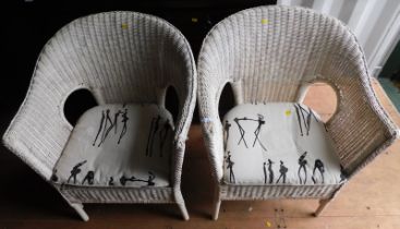 A pair of painted wicker armchairs.