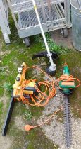 A Land Xcape electric chain saw, together with a Black & Decker electric hedge trimmer, and a strimm